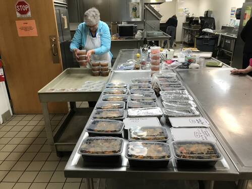 TBE Caring Community Member packages meals in the TBE kitchen